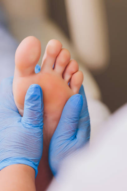 istock Therapist hands in protective gloves massaging woman's feet. 1295707503