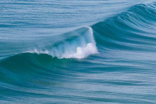 istock Wave breaking in turquoise calm ocean 1295713261