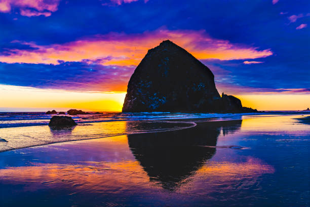 colorato tramonto haystack rock reflection canon beach oregon - reflection water rock beach foto e immagini stock