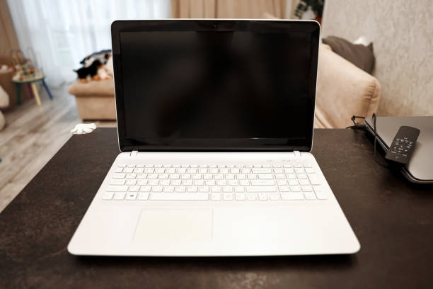 istock A laptop with a blank black screen in an angular position on a table against a blurred room background. The concept of workplace, office, coworking. 1295715918
