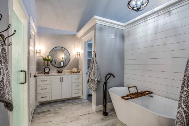 istock Light and bright bathroom with shiplap walls and round mirror 1295718032