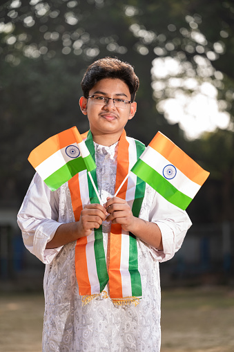 Young Indian boy child with Indian National Tricolor flag, celebrating Independence day or Republic Day of India.