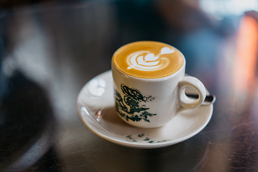 Image of a cafe latte with Malaysian traditional coffee cup in a cafe