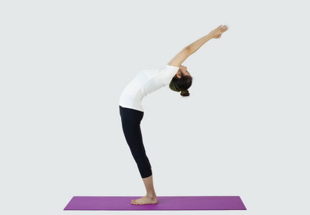 istock Beautiful young woman practicing yoga, stretching in yoga studio 1295720643