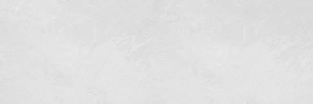 istock White concrete stone surface paint wall background, Grunge cement paint texture backdrop, White rough concrete stone wall background, Copy space for interior design background, banner, wallpaper 1295722388