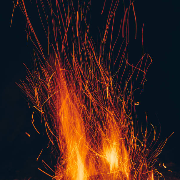 istock Sparks from fire in dark. Tourist night bonfire. 1295722621