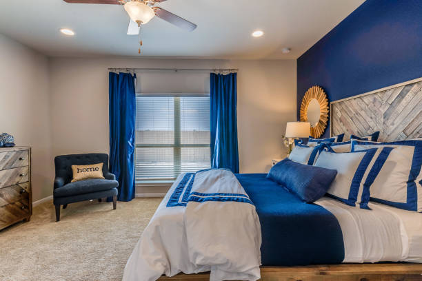 istock Blue paint, curtains, chair and bedding in blue bedroom 1295725669