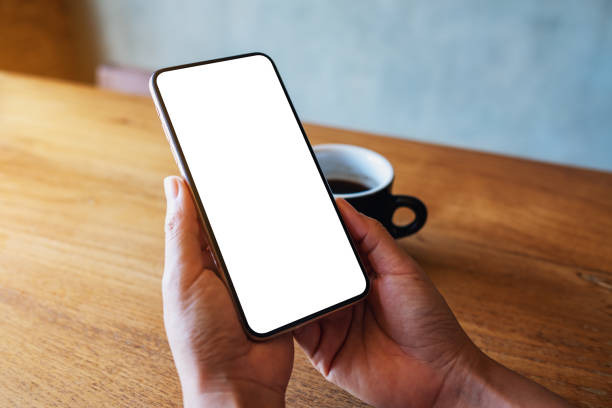 istock a woman holding mobile phone with blank white desktop screen 1295729750