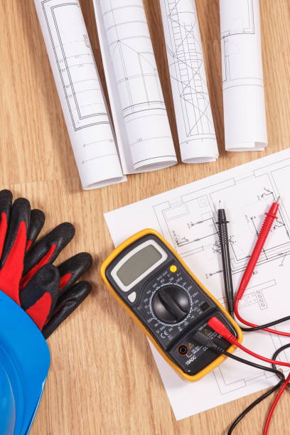 istock Electrical diagrams, protective helmet with gloves and multimeter for measurement in electrical installation 1295729931