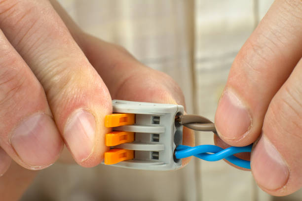 istock man connects the twisted ends of the wires using compact splicing connector 1295734223