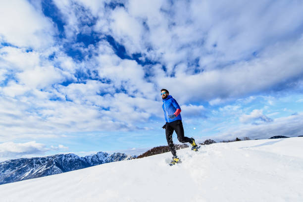 training im schnee mit bergab laufenden schneeschuhen - winter snowshoeing running snowshoe stock-fotos und bilder