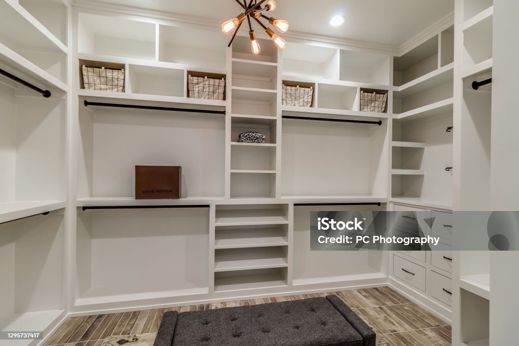 Built in shelves in luxury master closet Modern light fixture in center of walk-in closet Walk-in Closet Stock Photo