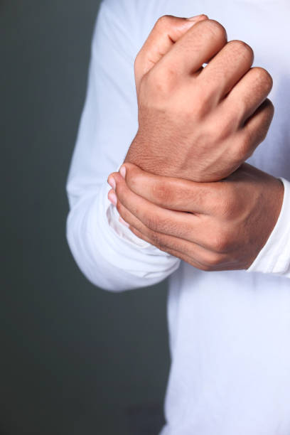 istock Young man in suffering wrist pain, close up 1295738323