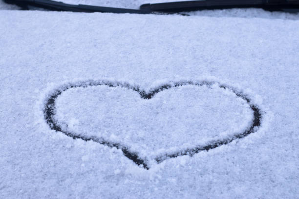 istock heart on a snow-covered car hood 1295739355