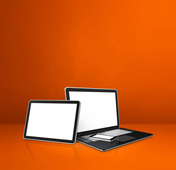 istock Laptop, mobile phone and digital tablet pc on orange office desk 1295739376