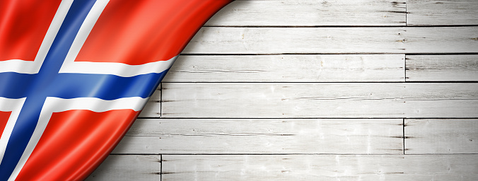 Norway flag on old white wall. Horizontal panoramic banner.