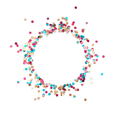 A round frame made of multicolored shiny metallized confetti is on a white background. Festive layout. Flat lay. Top view. Copy space.