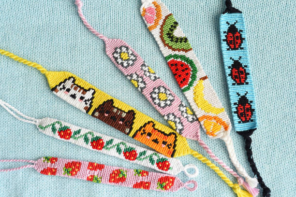 DIY friendship bracelets with alpha pattern Strawberry on woven background