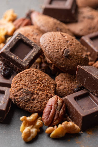 istock Sweet background, chocolate slices, cookies and mixed nuts on concrete background with copy space. 1295743454