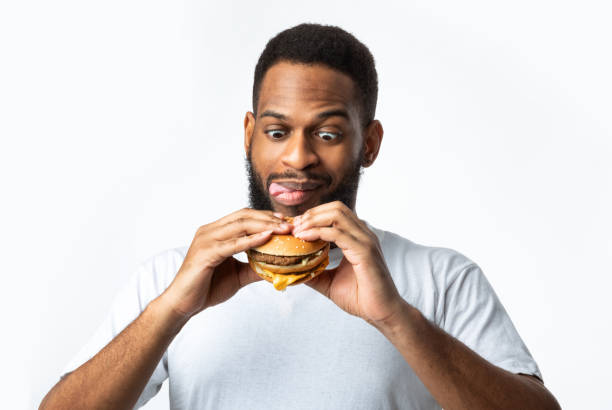 istock Hungry Black Man Holding Tasty Burger Standing On White Background 1295744752