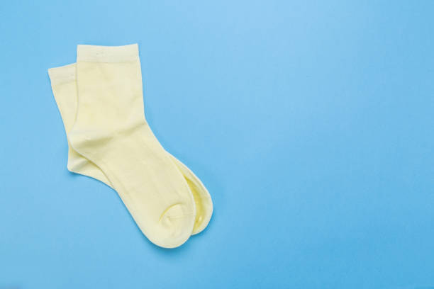 istock yellow new socks stacked on a blue background. top view. 1295744793