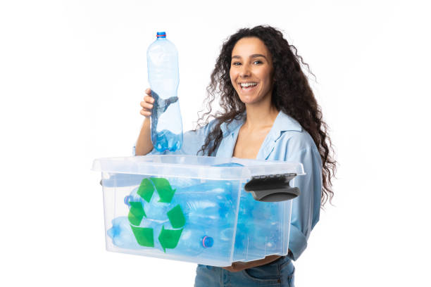 istock Woman Putting Used Plastic Bottle To Recycling Box, Studio Shot 1295745446