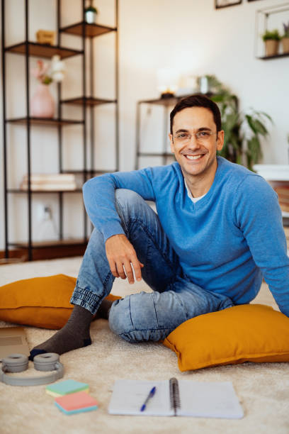istock Mature man working at home during quarantine, looking at camera and smiling 1295746559