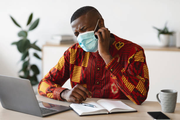 istock Stressed Black Man In Protective Medical Mask Scratching Face, Having Itchy Skin 1295746590