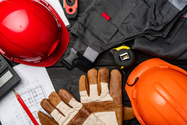 istock Construction worker unifrom, hardhat and blueprints on wooden background 1295748041