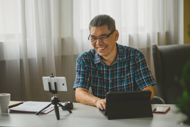 istock Mature man having a video chat in his living room using his mobile phone 1295748314