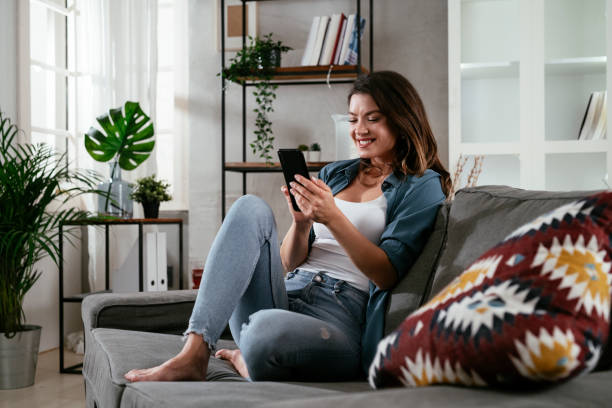 istock Happy young woman using the phone at home. 1295748563