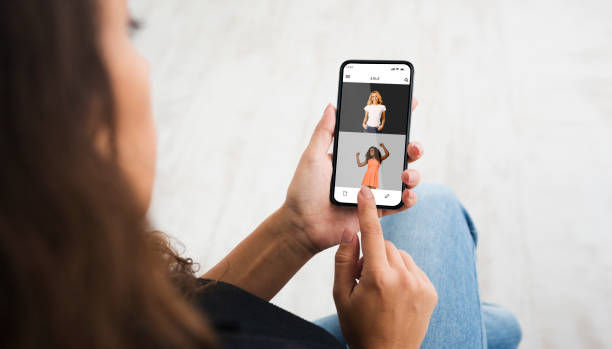 istock Woman using smartphone browsing online fashion store website 1295749756