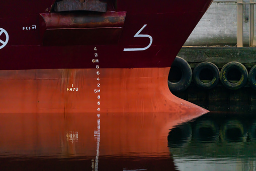Close up image of the bow and bulb of a large steel cargo ship.