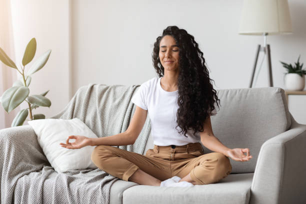 istock Peaceful brunette lady sitting on couch, meditating 1295752668