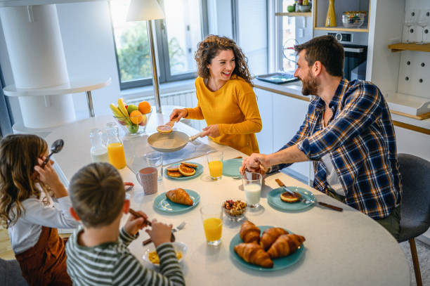istock Young happy family communicating while having breakfast in the kitchen 1295752991