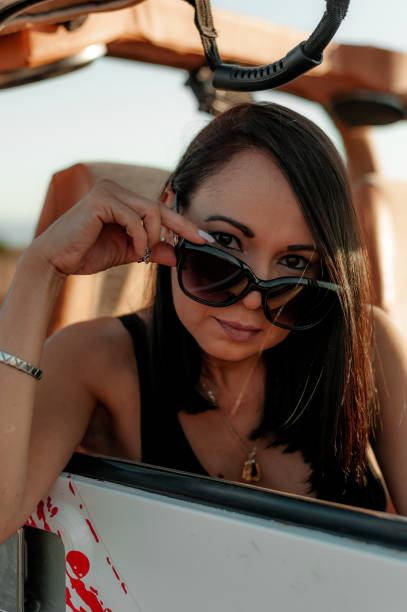 istock Woman looking outside car window using sunglasses 1295753833