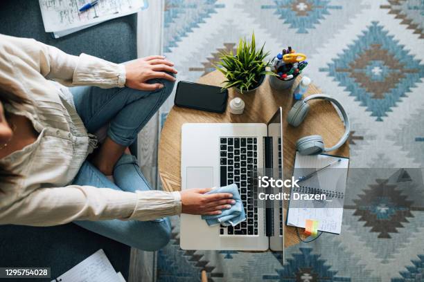 Woman Wiping The Surface Of Laptop In Home Office Stock Photo - Download Image Now - Cleaning, Laptop, Portable Information Device