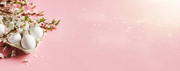 istock White eggs and twigs with flowers on pink background 1295754719