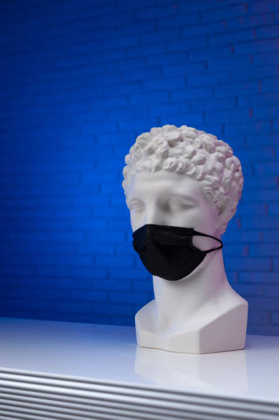 istock A white plaster statue wearing a disposable protective medical mask covering its face 1295754829