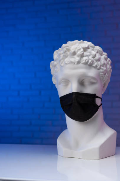 istock A white plaster statue wearing a disposable protective medical mask covering its face 1295754832