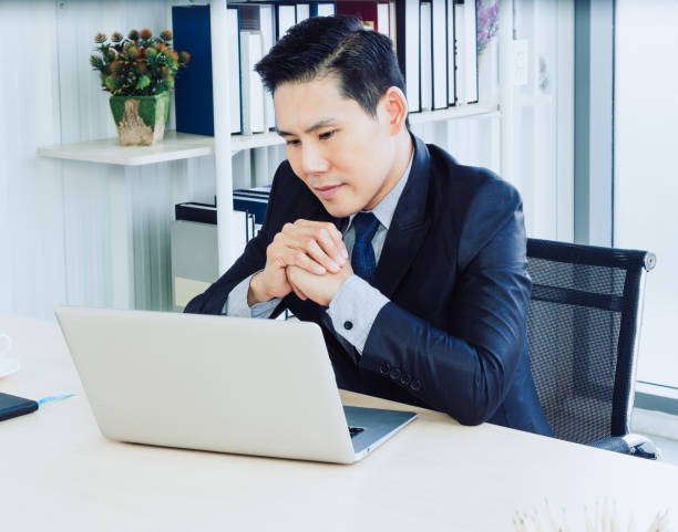 istock Asian handsome businessman in suit working with laptop computer on desk in office. 1295758890