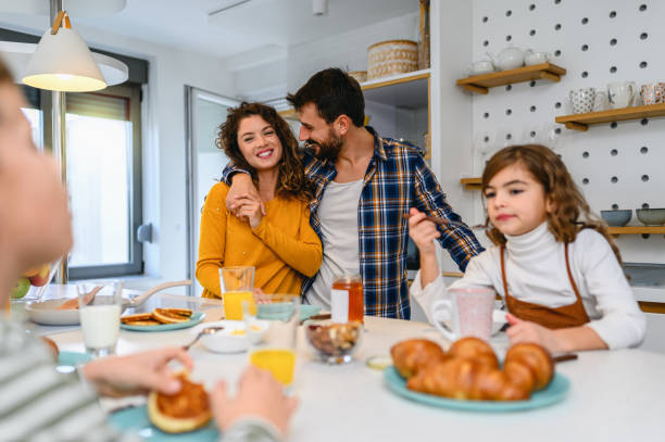 istock Young happy family communicating while having breakfast in the kitchen 1295758917