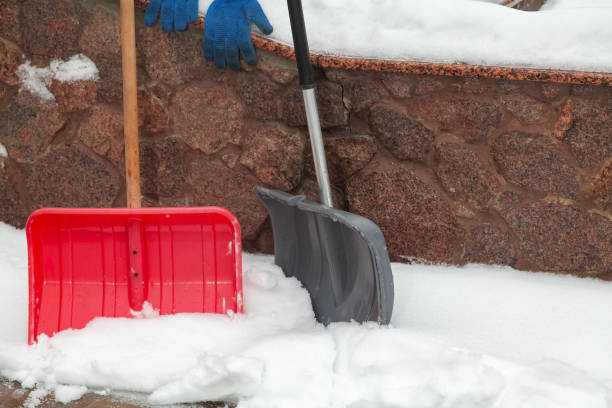 istock Two plastic snow shovels stand in front of  fence 1295759089