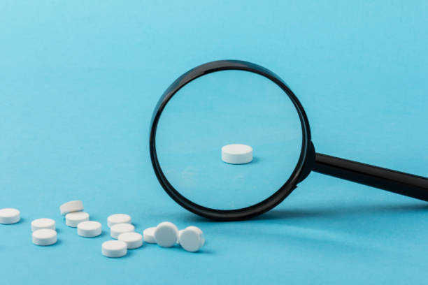 istock Concept - pharmaceutical testing, testing of medicines, magnifying glass, tablets on a blue background. Doping control. 1295759204