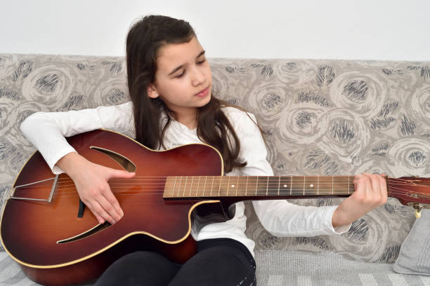 istock Young girl playing the guitar 1295760488