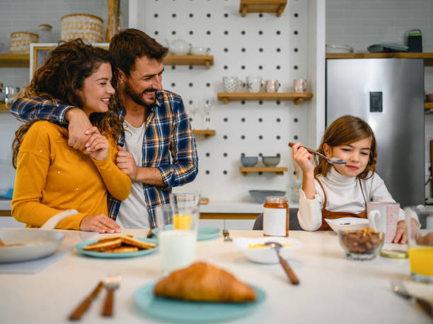 istock Young happy family communicating while having breakfast in the kitchen 1295760524