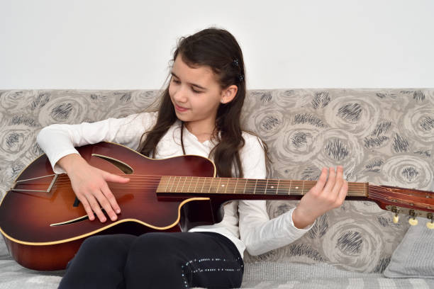 istock Young girl playing the guitar 1295760736