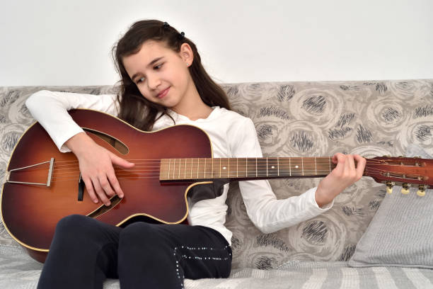 istock Young girl playing the guitar 1295760753