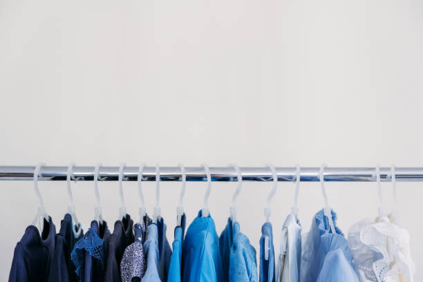 schnelle mode, nachhaltige mode, minimalistische garderobe. vielzahl von weiblichen blauen kleidung auf hängen auf weißem hintergrund mit kopierraum. mode minimalstil banner - fasten stock-fotos und bilder