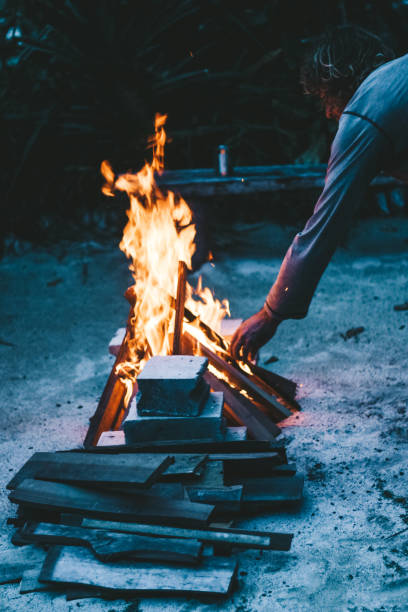 istock Men putting wood on the fire 1295762369